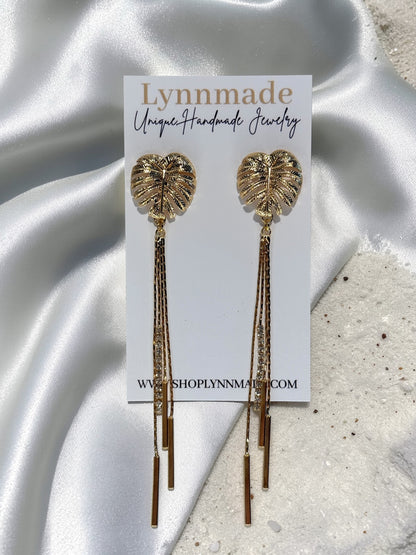 Pair of gold Long Monstera Tassel Earrings with textured leaf studs and shimmering chain fringe. Lynnmade Jewelry 