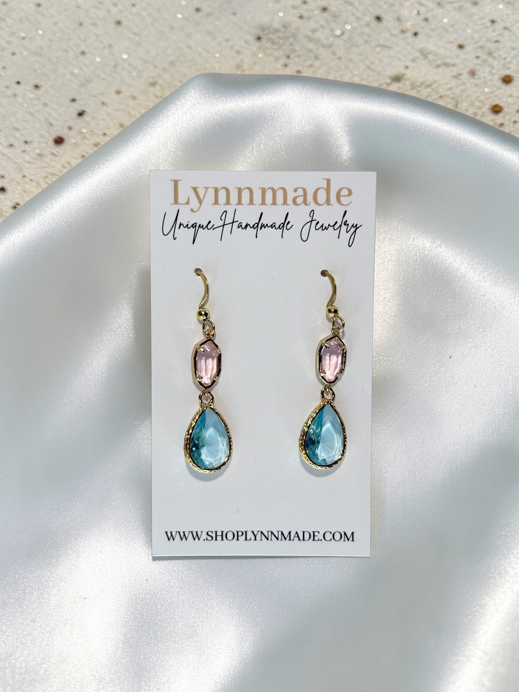 Handmade gold teardrop earrings with a seafoam blue crystal and a blush pink accent