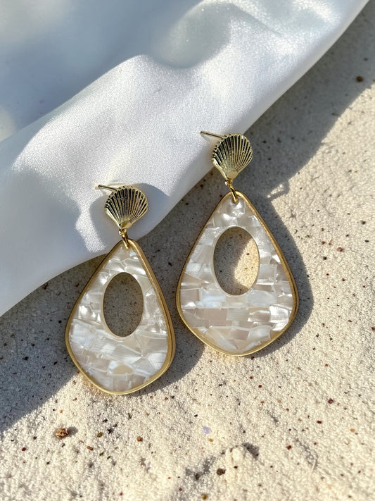 Luminous Tide Mother of Pearl Shell Drop Earrings in Gold or Silver on white silk and sand background.