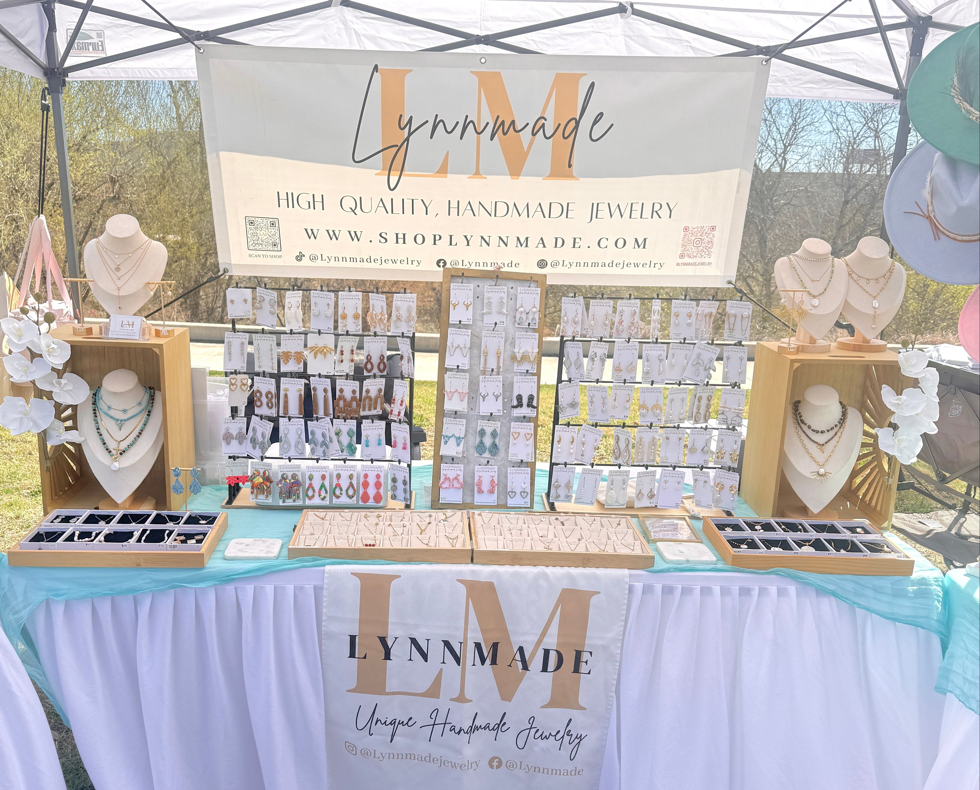 LynnMade jewelry booth with various jewelry items on display outdoors.